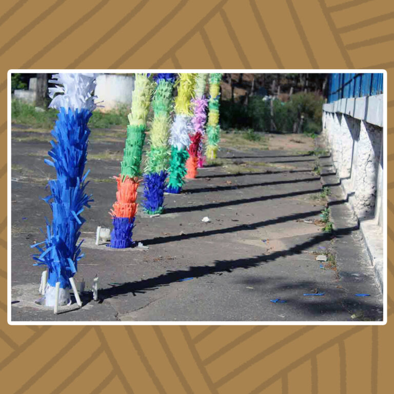 Para todos verem: Sobre o chão de concreto firme, buracos estão preenchidos pelos pés dos mastros das bandeiras erguidas.